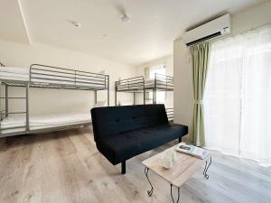 尾道市bHOTEL Yutori - 1Br Apt with Balcony for 4 Ppl in Onomichi的客厅配有沙发和两张双层床。