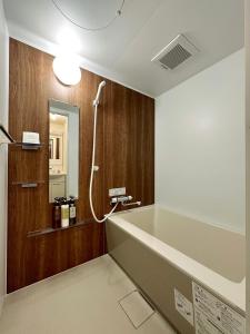 a bathroom with a large bath tub and a shower at bHOTEL Nagomi - Stylish 1 BR Apt near City Centre for 3Ppl in Hiroshima