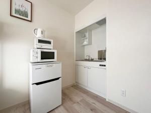 尾道市bHOTEL Yutori - 1Br Apt with Balcony for 4 Ppl in Onomichi的白色的厨房配备了微波炉和冰箱。