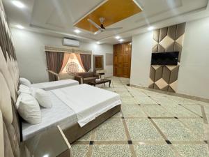 een slaapkamer met een bed en een woonkamer bij Royal Executive Inn Guest House in Islamabad