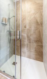 a shower stall with a glass shower door at Espaces Gîtes in Sainte-Escobille