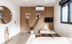 ein Wohnzimmer mit einem weißen Sofa und einem Tisch in der Unterkunft Espaces Gîtes in Sainte-Escobille