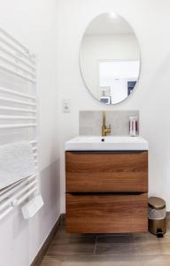 ein Bad mit einem Waschbecken und einem Spiegel in der Unterkunft Espaces Gîtes in Sainte-Escobille
