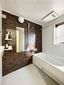 尾道的住宿－bHOTEL Yutori - Attractive 1Br Apt for 4 people in Onomichi，带浴缸和盥洗盆的浴室
