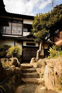 una casa con escaleras delante de una casa en bLOCAL Bingo Yamamo - Experience at Traditional Japanese House en Onomichi