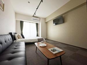 un soggiorno con divano e tavolo di bHOTEL Nagomi - Luxe Apt for 3Ppl City Center a Hiroshima