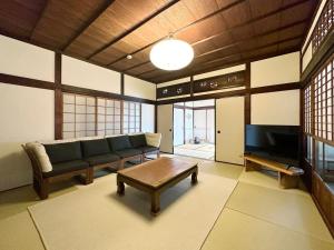 a living room with a couch and a coffee table at bLOCAL Bingo Yamamo - Experience at Traditional Japanese House in Onomichi