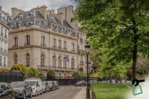 duży budynek z samochodami zaparkowanymi przed nim w obiekcie Hotiday Collection Paris - Arc de Triomphe w Paryżu