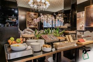 un buffet avec des assiettes et d'autres aliments sur une table dans l'établissement Hotiday Collection Paris - Arc de Triomphe, à Paris