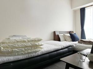 廣島的住宿－bHOTEL Nagomi - 1 Bedroom Apt in City Centre w balcony for 3 Ppl，客厅配有带枕头的沙发