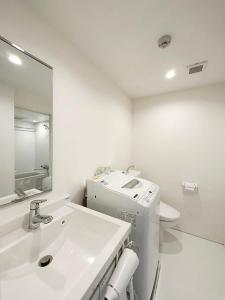 Baño blanco con lavabo y aseo en bHOTEL Arts Dobashi - Studio Apt for 6 Ppl Near Peace Park en Hiroshima