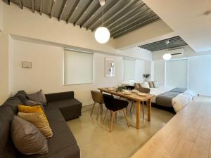 uma sala de estar com um sofá e uma mesa em bHOTEL Arts Dobashi - Studio Apt for 6 Ppl Near Peace Park em Hiroshima