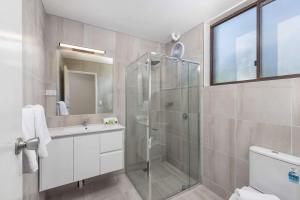 a bathroom with a glass shower and a sink at Econo Lodge Lilydale in Lilydale