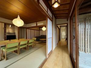 a dining room with a table and green chairs at bLOCAL Itsuki - Charming Private House in Miyajimaguchi Near Itsukushima Shrine Upto 18 ppl in Hatsukaichi