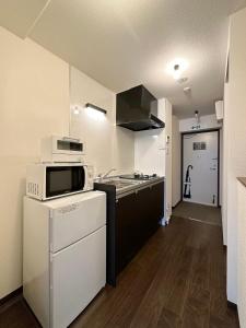 a kitchen with a sink and a microwave at bHOTEL Nagomi - Cozy 1BR Apartment with Balcony for 3Ppl in Hiroshima