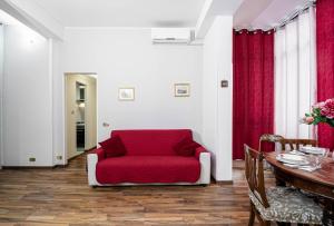 a living room with a red couch and a table at House Serena in Rome