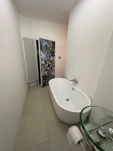 a white bathroom with a tub and a glass table at 2 bedroom flat Wembley in London