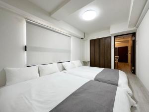 a bedroom with a white bed and a large window at Mitao bld - Beautiful Apt for 10Ppl Very Near to Peace Park in Kami-nagarekawachō