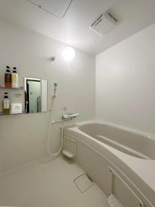 a white bathroom with a tub and a mirror at Mitao bld - Beautiful Apt for 10Ppl Very Near to Peace Park in Kami-nagarekawachō