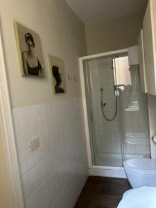 a bathroom with a shower with a picture of a man at Maison Vert appartamento in centro storico a Modena in Modena +8 photos