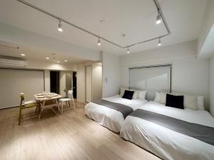 a hotel room with two beds and a table at bHOTEL F-style - 1BR Apt Great Location for 6Ppl in Hiroshima