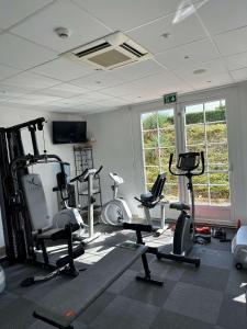 a gym with several treadmills and exercise bikes in a room at La Bonbonniere - Sure Hotel Collection by Best Western in Dijon