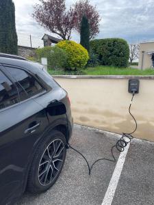 un'auto è collegata a un caricabatterie per auto elettriche di La Bonbonniere - Sure Hotel Collection by Best Western a Digione