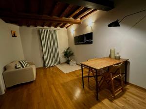 a living room with a table and a chair at Maison Vert appartamento in centro storico a Modena in Modena