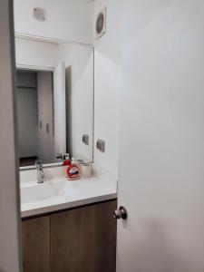 a bathroom with a sink and a mirror at Apartamento en Miraflores con AC in Lima