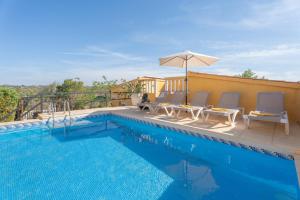 a swimming pool with lounge chairs and an umbrella at Casa Rosa in Torrent