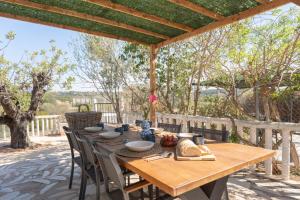 a wooden table and chairs on a patio with trees at Casa Rosa in Torrent