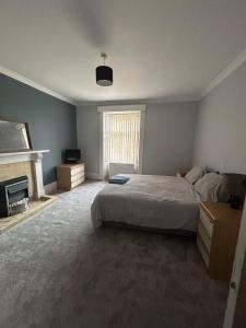 - une chambre avec un grand lit et une cheminée dans l'établissement Manor House Hotel, à Thurso