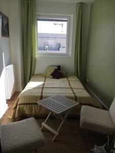 - une petite chambre avec un lit et une fenêtre dans l'établissement Appartement 70m2 terrasse vue jardin 10min Paris centre, à Levallois-Perret