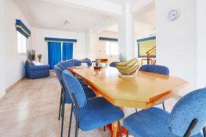 a dining room with a wooden table and blue chairs at Villa Chloe in Ayia Napa