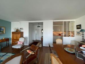 una sala da pranzo e un soggiorno con tavolo e sedie. di Appartement 70m2 terrasse vue jardin 10min Paris centre a Levallois-Perret