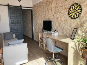 Habitación con escritorio, TV y silla. en AltHouse Canet lo Roig, en Canet lo Roig