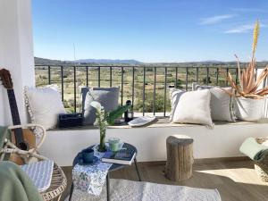 Un balcón con almohadas y una mesa con vistas. en AltHouse Canet lo Roig, en Canet lo Roig