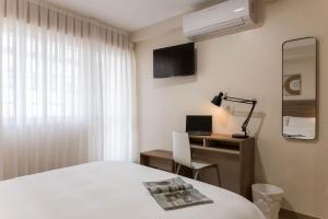 a bedroom with a bed and a desk with a computer at Vigo Bay Apartments by Olala Homes in Vigo