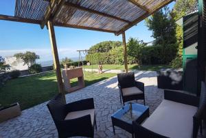 a patio with chairs and a table and a pergola at Il covo degli Amanti in Fara in Sabina