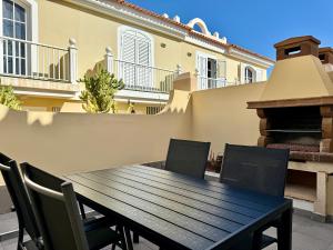 a wooden table and chairs on a patio at Casa Simone - Luxury Sunny House in Caleta De Fuste