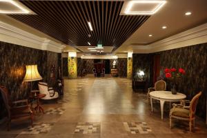 a hallway with tables and chairs in a building at Hotel Senator in Timişoara