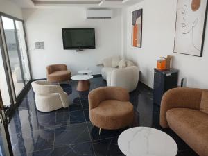 ein Wohnzimmer mit Stühlen und einem Flachbild-TV in der Unterkunft Chez Doki Sen hôtel in Sali Nianiaral