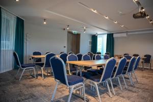 una sala de conferencias con mesas y sillas. en NN Boutique Hotel****, en Tiszaújváros