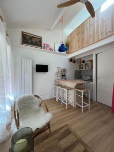 a kitchen with a couch and a table in a room at Petite maison au cœur de la pinède in Lacanau +1 photo