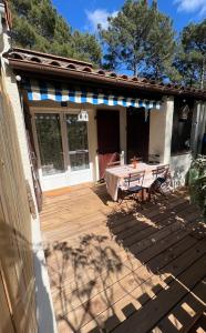 a patio with a table on top of a house at Petite maison au cœur de la pinède in Lacanau