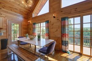 a dining room with a table and chairs and windows at Berkshire Vacation Rentals: Great Barrington Cabin Sleeps 14 Walk To Town in Great Barrington