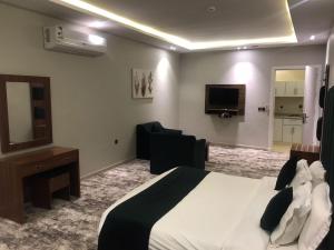 a hotel room with a bed and a flat screen tv at اضواء السلام للشقق المخدومة in Medina