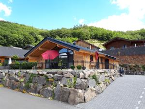a building with a stone wall next to a house at Blockhaus Edelweiss in Rieden