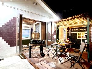 a small patio with a table and a tv on it at Rush Awaji Guppy - Seaside Holiday Home - Self Check-In Only in Awaji