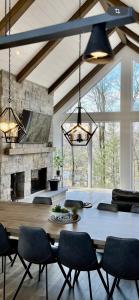 a living room with a table and a stone fireplace at The Chic Shack - Golf, Ski, SPA in Saint-Faustin